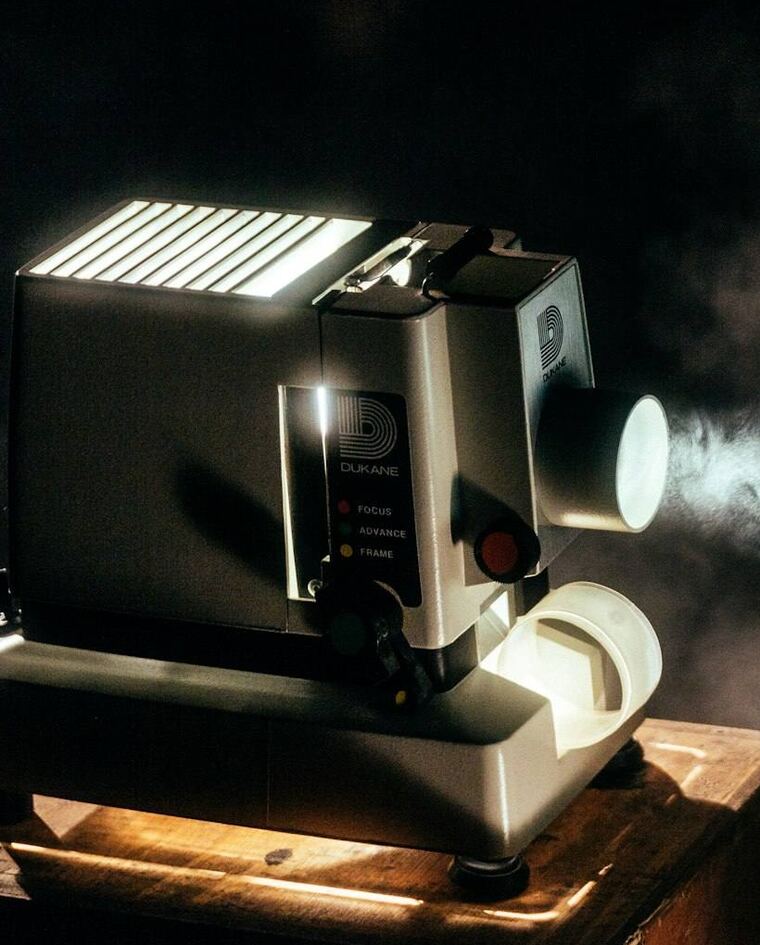 A film projector throwing light in a dark room